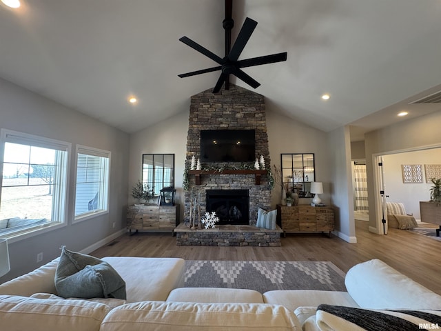 living room featuring light hardwood / wood-style flooring, a fireplace, high vaulted ceiling, and ceiling fan