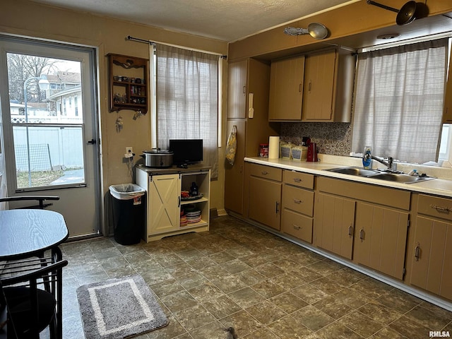 kitchen featuring sink, backsplash, and a textured ceiling