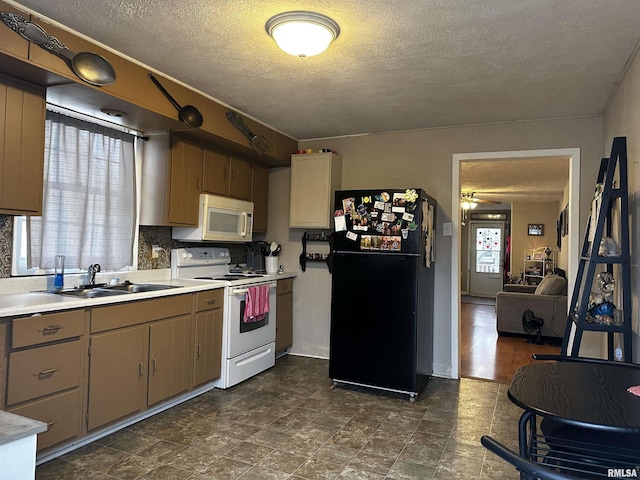 kitchen featuring white appliances, a healthy amount of sunlight, sink, and a textured ceiling