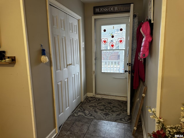 entryway featuring dark tile patterned floors