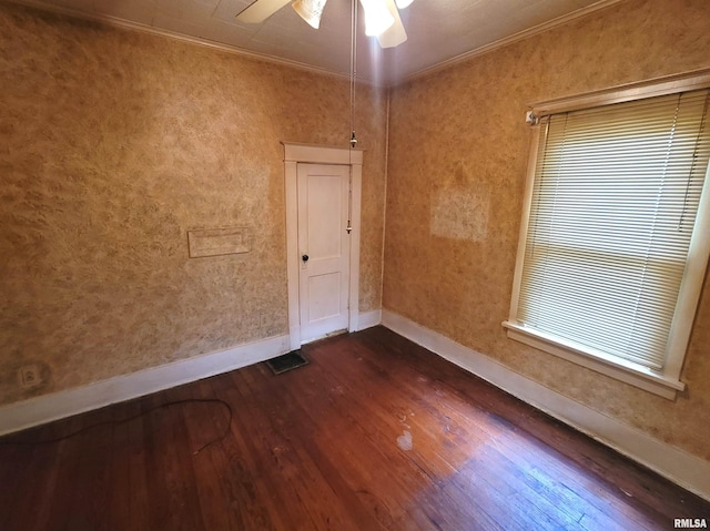 empty room featuring ceiling fan, ornamental molding, and dark hardwood / wood-style flooring