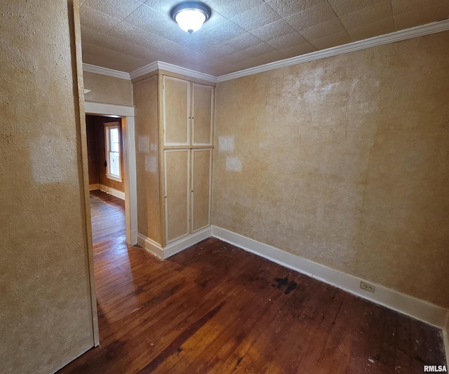 spare room with crown molding and dark hardwood / wood-style floors