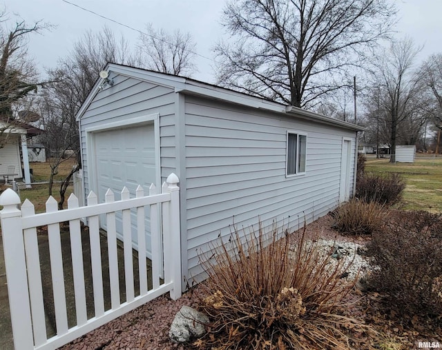 view of side of property with a garage and an outbuilding