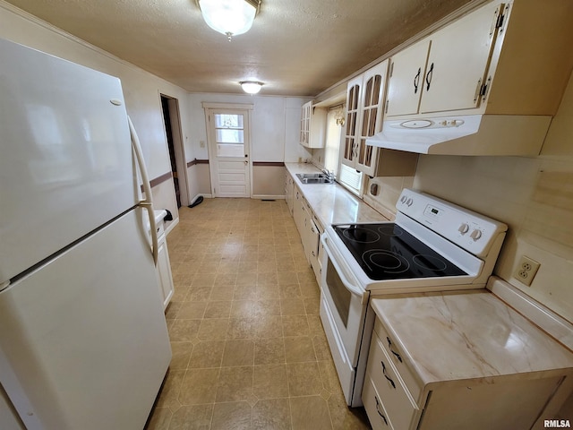 kitchen featuring sink, white appliances, a textured ceiling, and white cabinets