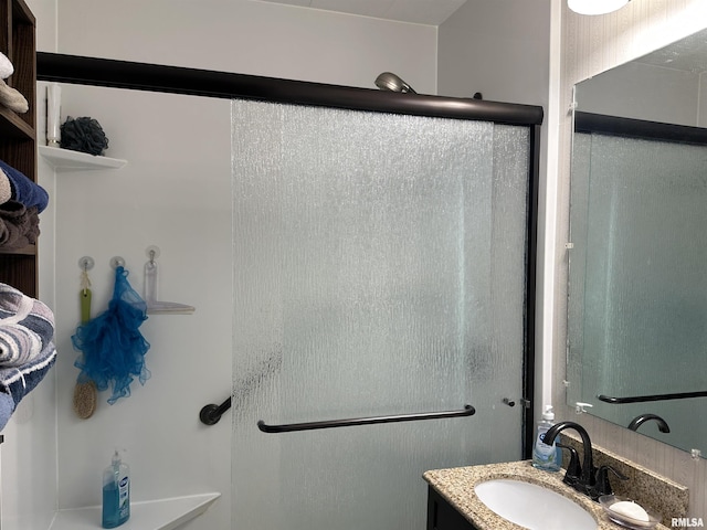 bathroom featuring walk in shower and vanity