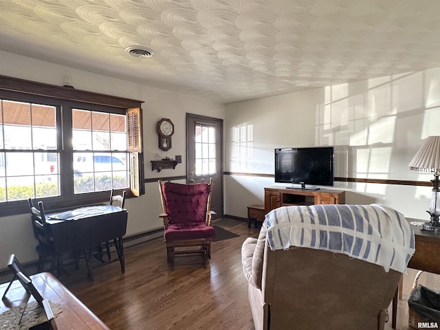 living room featuring a baseboard heating unit and hardwood / wood-style floors