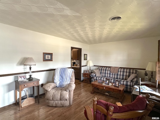 living room with hardwood / wood-style flooring and a textured ceiling