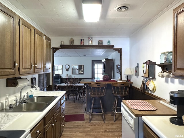 kitchen with crown molding, dark hardwood / wood-style flooring, dishwasher, and sink