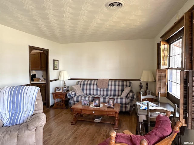 living room featuring a wealth of natural light, wood-type flooring, and a textured ceiling