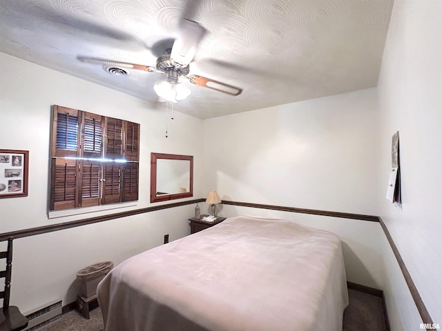 carpeted bedroom featuring a baseboard radiator and ceiling fan