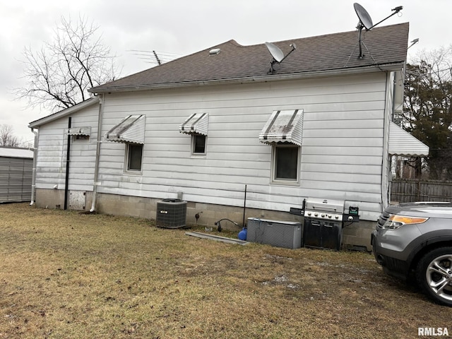 view of property exterior featuring central AC unit and a lawn