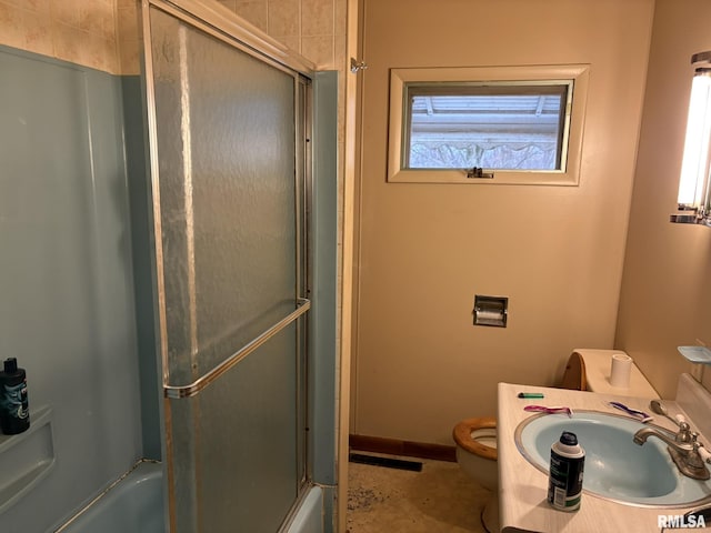 full bathroom with vanity, bath / shower combo with glass door, and toilet