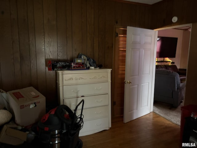 bedroom with hardwood / wood-style flooring and wooden walls