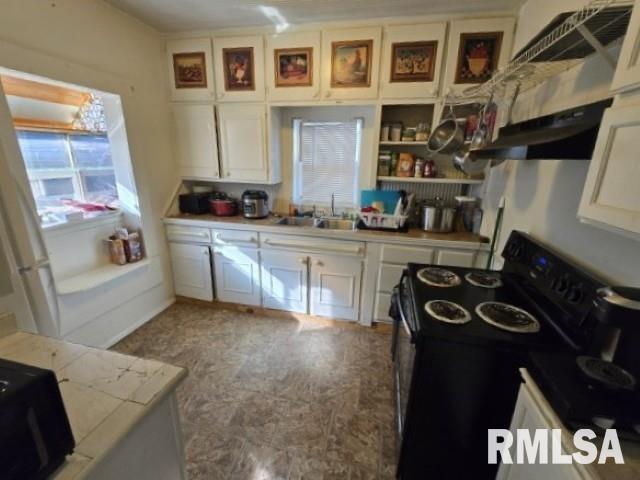 kitchen featuring white cabinetry, sink, and black range with electric cooktop