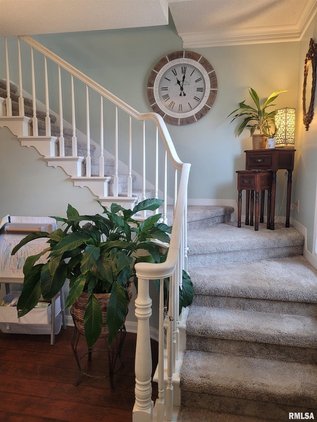 stairway with ornamental molding and wood-type flooring