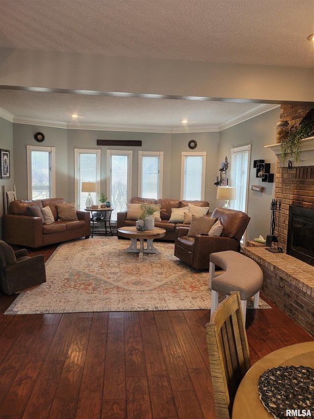 living room featuring hardwood / wood-style flooring, ornamental molding, and a brick fireplace