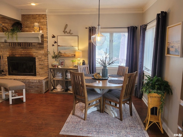 dining space featuring crown molding, a brick fireplace, and dark wood-type flooring