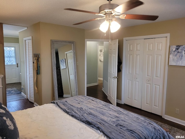 bedroom with ceiling fan, dark hardwood / wood-style floors, and a textured ceiling