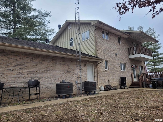 rear view of house featuring a balcony and central AC