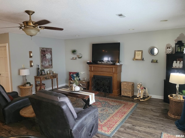 living room with ceiling fan, hardwood / wood-style flooring, and a textured ceiling