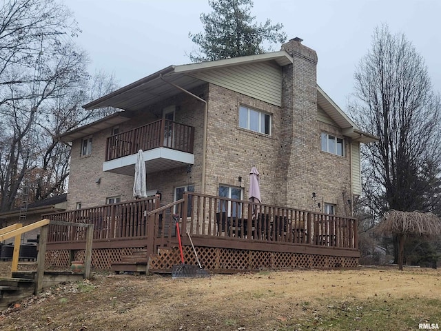 back of property featuring a balcony and a deck