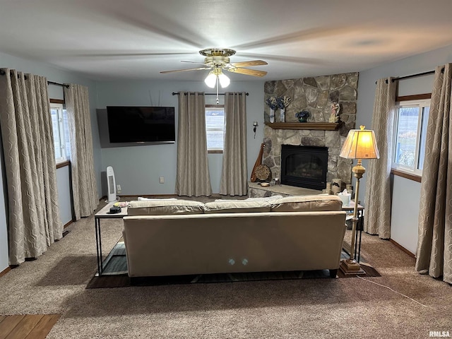 living room with ceiling fan, carpet, and a fireplace