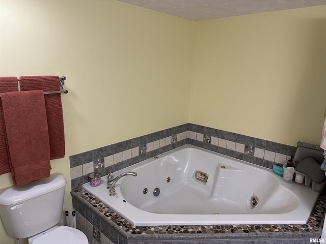 bathroom featuring toilet, tiled bath, and a textured ceiling