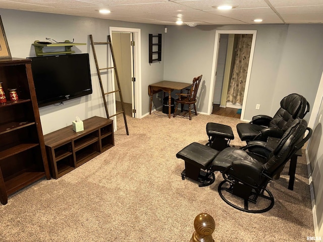 carpeted living room with a drop ceiling