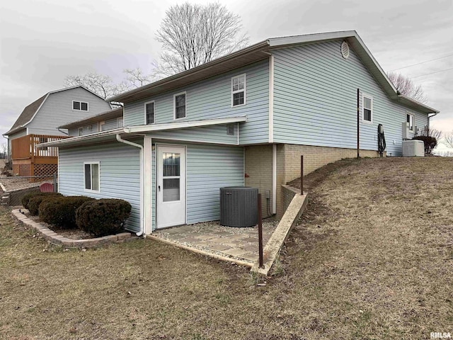 rear view of house with a patio area, central AC, and a lawn