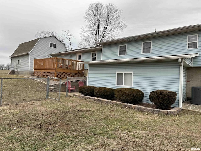 rear view of property with a yard, central AC, and a deck