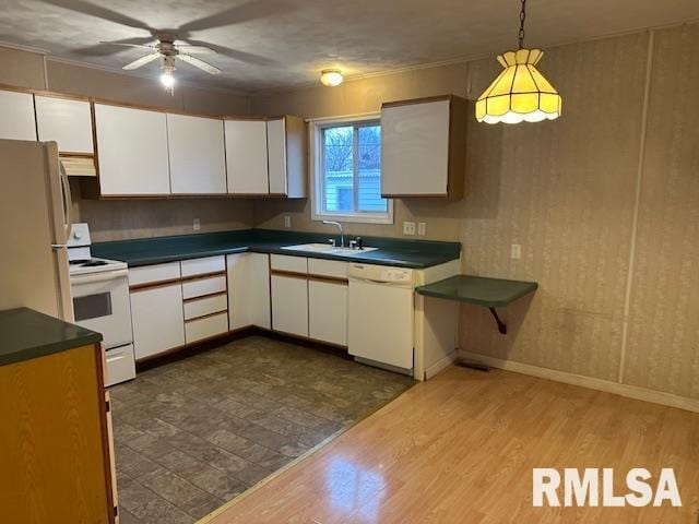 kitchen featuring white cabinetry, sink, white appliances, and decorative light fixtures