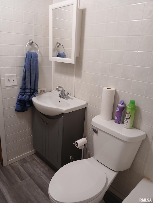 520 Dewey St, Eldorado, IL 62930 - bathroom with wood finished floors, toilet, vanity, and tile walls