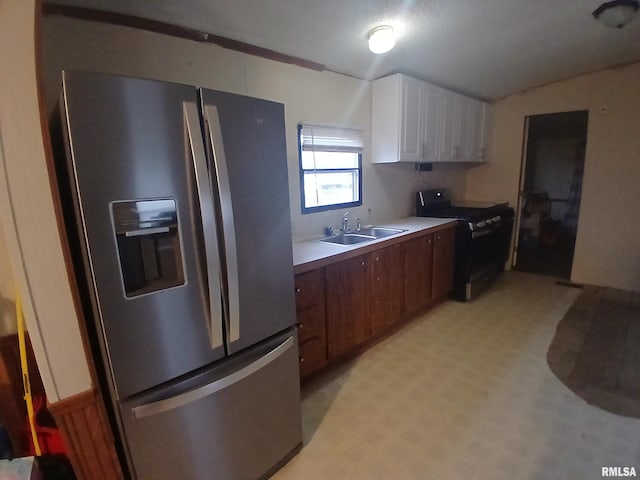 520 Dewey St, Eldorado, IL 62930 - kitchen with light countertops, stainless steel refrigerator with ice dispenser, a sink, black gas stove, and light floors