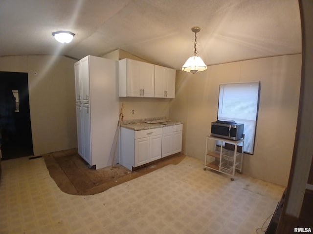 520 Dewey St, Eldorado, IL 62930 - kitchen featuring stainless steel microwave, hanging light fixtures, white cabinetry, and vaulted ceiling