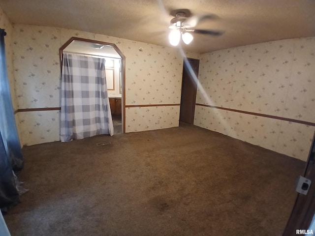 520 Dewey St, Eldorado, IL 62930 - unfurnished room featuring a ceiling fan, wallpapered walls, and dark colored carpet