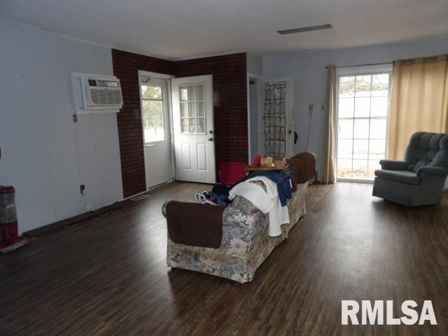 living room with dark hardwood / wood-style flooring and a wall unit AC