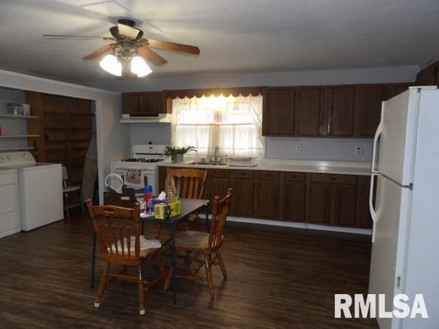 kitchen featuring dark wood-type flooring, sink, white appliances, ceiling fan, and independent washer and dryer