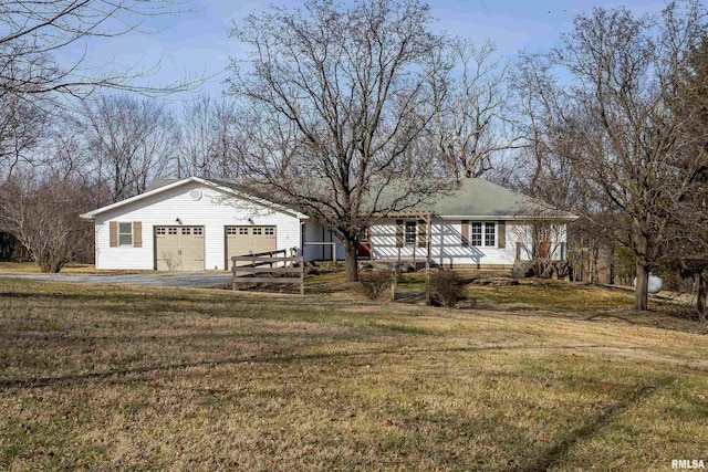 ranch-style house with a garage and a front lawn