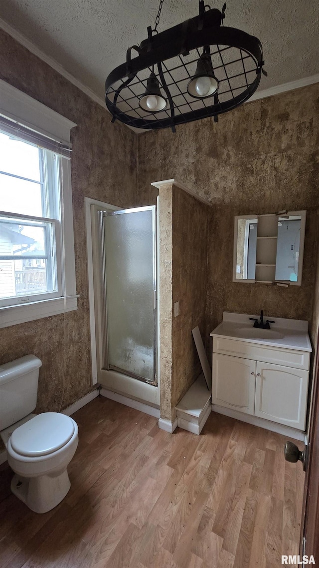 bathroom featuring hardwood / wood-style flooring, ornamental molding, a textured ceiling, and walk in shower