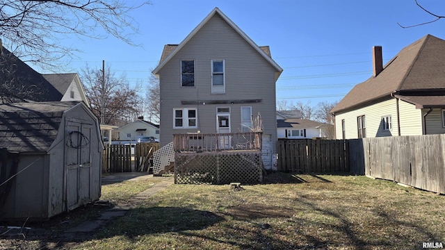 back of property featuring a storage unit, a deck, and a lawn