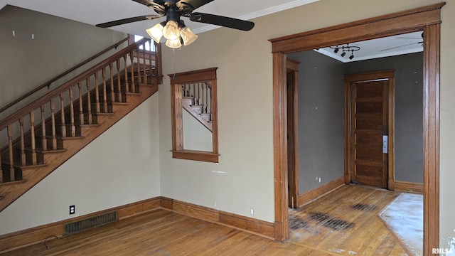 entrance foyer featuring hardwood / wood-style flooring, ceiling fan, and crown molding