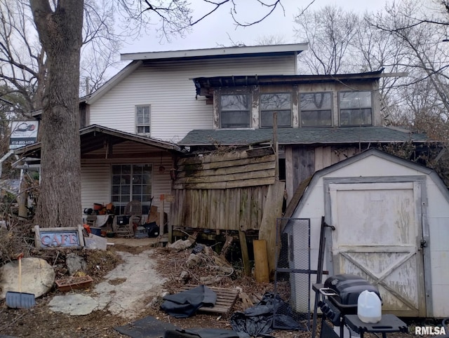 back of house with a shed