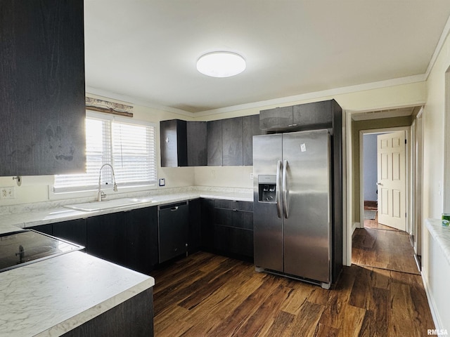 kitchen featuring black dishwasher, sink, dark wood-type flooring, and stainless steel fridge