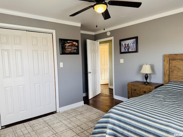 bedroom with hardwood / wood-style flooring, ornamental molding, a closet, and ceiling fan