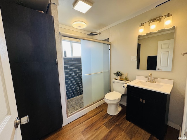 bathroom with an enclosed shower, hardwood / wood-style floors, vanity, and toilet