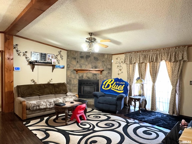 living room featuring a stone fireplace, crown molding, a textured ceiling, ceiling fan, and hardwood / wood-style floors