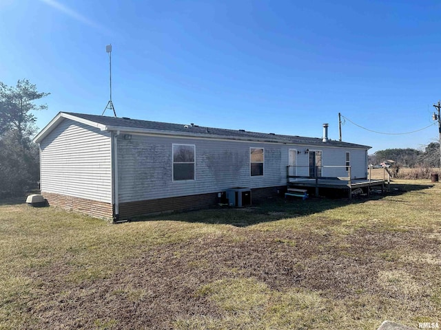 rear view of house featuring a wooden deck, central AC unit, and a yard