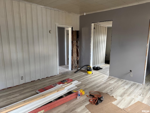 spare room with crown molding and light wood-type flooring