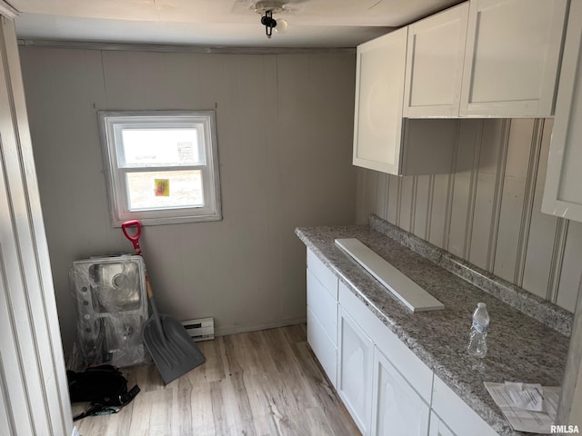 laundry area with white cabinetry, light stone countertops, light hardwood / wood-style floors, and a baseboard radiator