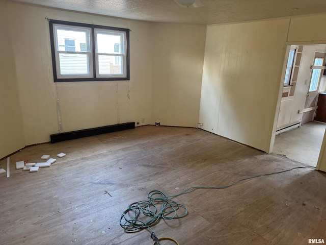 empty room featuring a baseboard heating unit